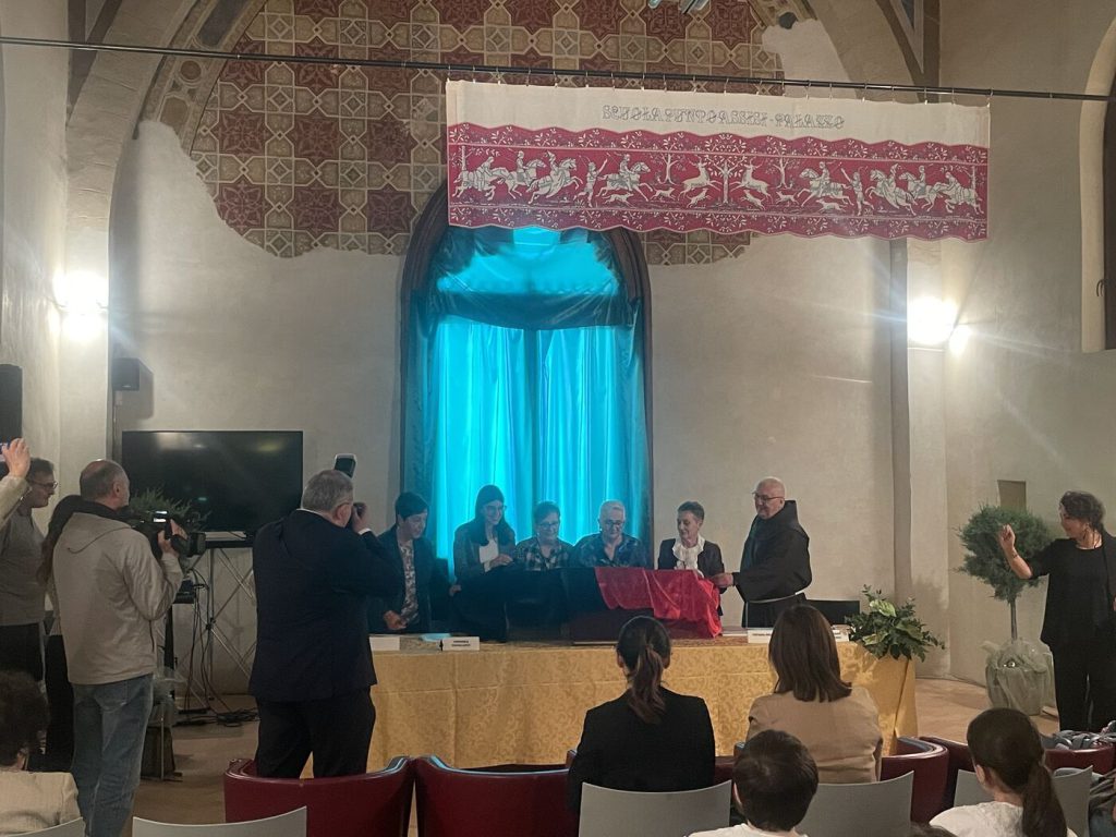 La presentazione a Palazzo Monte Frumentario, con l'arazzo della Scuola Punto Assisi